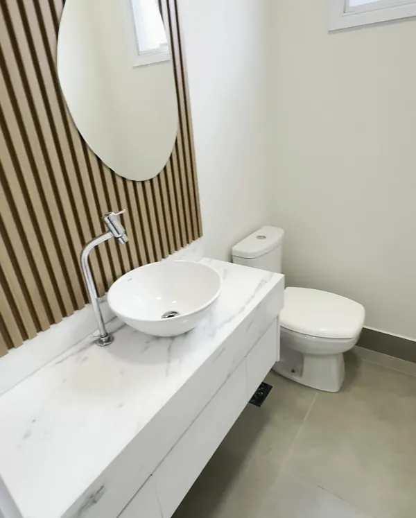 Lavabo com bancada em mármore e painel ripado